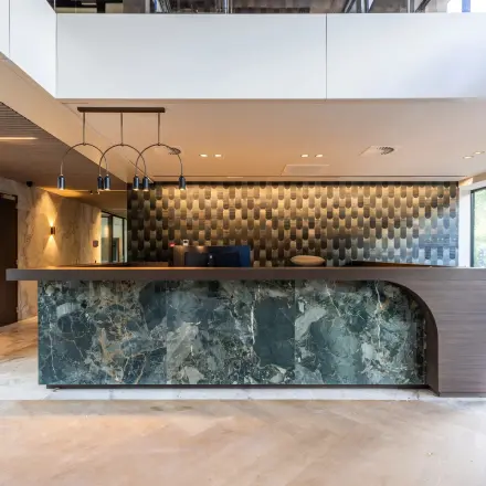 Lobby van een kantoorpand in Amsterdam Buitenveldert op Zwaansvliet 1, met een elegante balie en moderne verlichting, ideaal voor kantoorruimte huren.