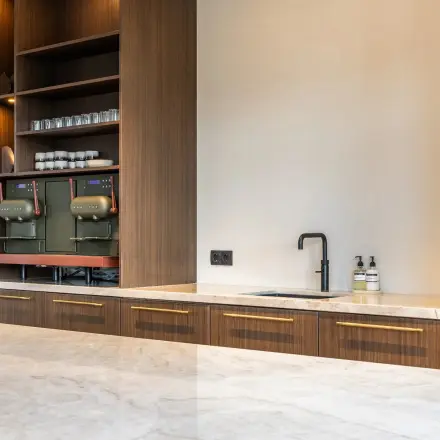 De pantry in het kantoorpand op Zwaansvliet 1 in Amsterdam Buitenveldert is stijlvol met een marmeren aanrecht en opbergkasten, ideaal om te huren.