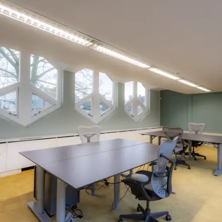 Lichte kantoorruimte huren in Amsterdam Centrum met moderne werkplekken en opvallende ramen, geschikt voor productief werk op Kerkstraat 204.