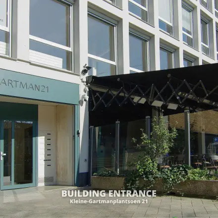Vooraanzicht van een kantoorpand op Kleine Gartmanplantsoen 21 in Amsterdam Centrum, met moderne entree en terras. Ideaal om kantoorruimte te huren in het hart van de stad.