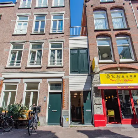 Kantoorpand gelegen aan de Korte Leidsedwarsstraat 133A in Amsterdam Centrum, met een karakteristieke gevel en diverse winkels aan de straatkant. Voorkant met fietsen en uitstalling.
