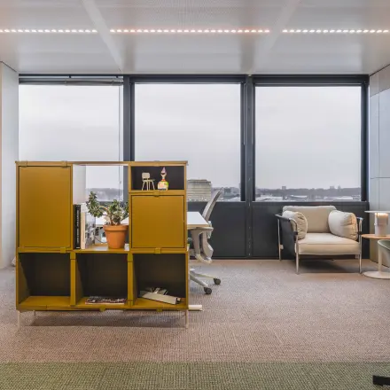 Gezellige kantoorruimte te huur op Piet Heinkade 55 in Amsterdam Centrum, met uitzicht op de stad, moderne bureaus, comfortabele stoelen en een stijlvolle scheidingswand.