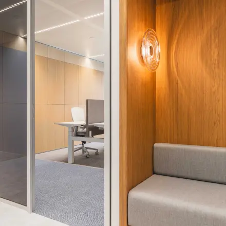 Moderne kantoorruimte huren in Amsterdam Centrum, met strakke houten en grijze elementen en een uitnodigende zitplek. Ideaal kantoorpand op Piet Heinkade 55 voor veelzijdig gebruik.