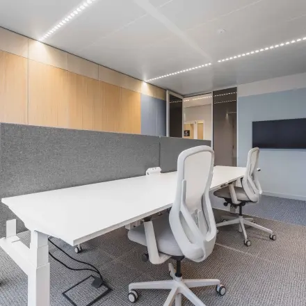 Moderne kantoorruimte met houten panelen op Piet Heinkade 55, Amsterdam Centrum, geschikt voor het huren van een kantoorpand. Meubilair bestaat uit witte bureaus en comfortabele stoelen.