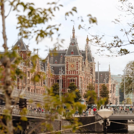 Uitzicht op een historisch kantoorpand aan de Prins Hendrikkade 14 in Amsterdam Centrum, gelegen aan het water met architectonische details.