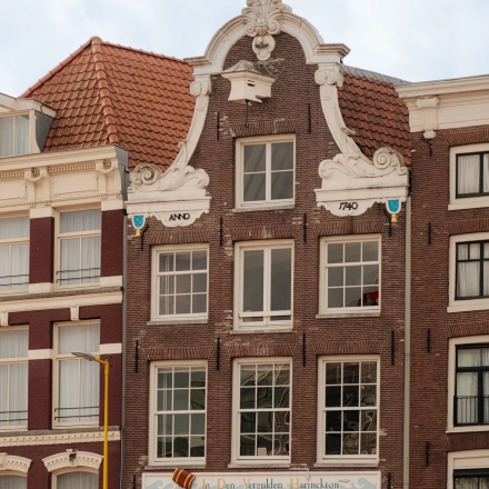 Gevel van een historisch kantoorpand op Prins Hendrikkade 14 in Amsterdam Centrum, karakteristieke architectuur, beschikbaar voor kantoorruimte huur.