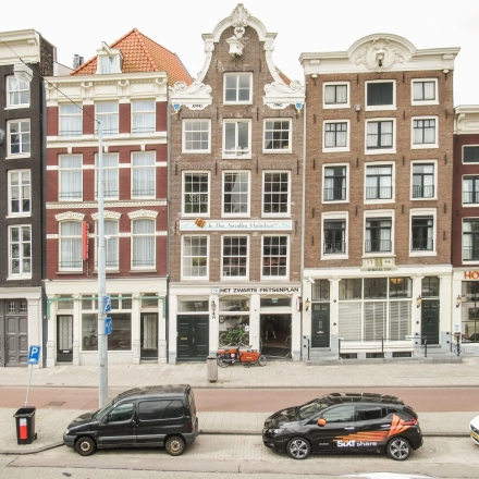 Gevel van een historisch kantoorpand aan de Prins Hendrikkade 14 in Amsterdam Centrum met meerdere etages en karakteristieke architectuur.