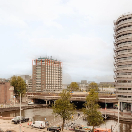 Uitzicht op de Prins Hendrikkade 14 in Amsterdam Centrum met omliggende gebouwen en verkeer. Geschikt als locatie voor kantoorruimte huren.
