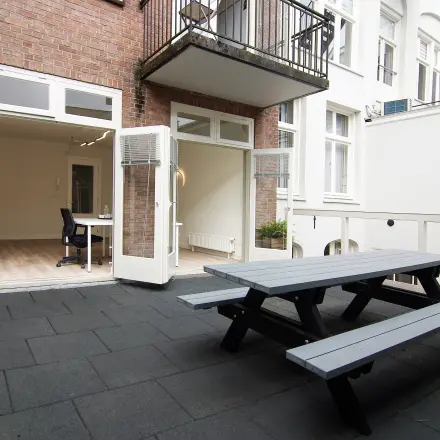 Kantoorruimte huren aan de Warmoesstraat 149-151 in Amsterdam Centrum met toegang tot een terras met picknicktafel. Binnenruimte is ongemeubileerd, ideale plek voor creatieve werkplekken.