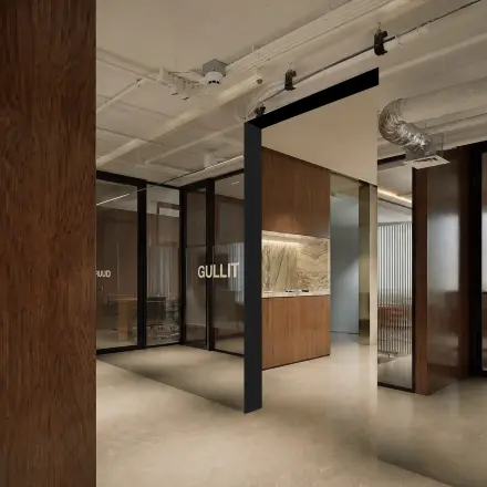 Moderne kantoorruimte in Amsterdam Centrum met glazen wanden en houten accenten, ideaal voor huur. De ruimte straalt een stijlvolle en professionele sfeer uit.