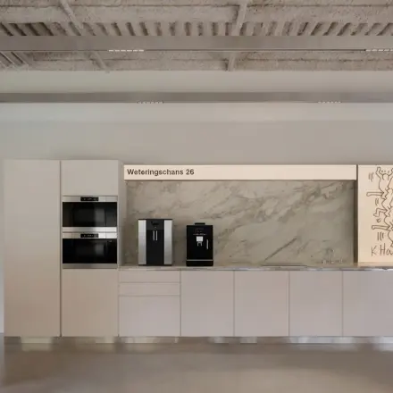 Stijlvolle kantoorruimte op de Weteringschans 126 in Amsterdam Centrum. Modern ingericht met een nette pantry en een vergadertafel, ideaal voor kantoorruimte huren.