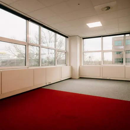 Leeg kantoor in kantoorpand op Overschiestraat 182, Amsterdam De Schinkel, met grote ramen en neutrale vloerbedekking. Ideaal voor kantoorruimte huren met uitzicht op de stad.