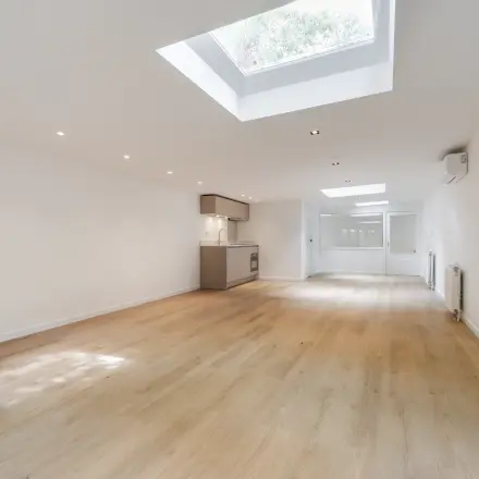 Lichte, open kantoorruimte op Schinkelkade 44, Amsterdam De Schinkel, met houten vloer, dakramen en een compacte keuken. Ideaal voor wie kantoren wil huren in een rustige omgeving.