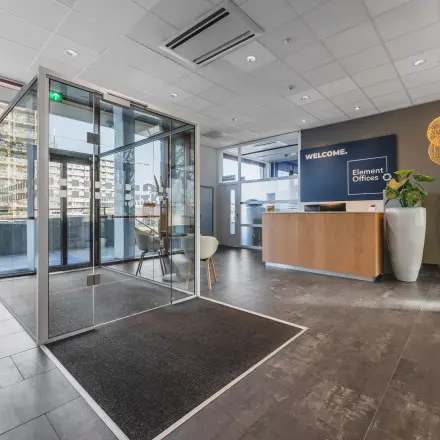 Ingang van een moderne kantoorruimte op Daalwijkdreef 47, Amsterdam Duivendrecht, met een receptiebalie en glazen deur. Huur hier je ideale kantoorpand.