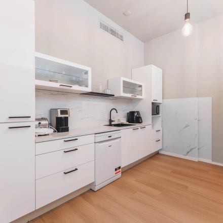 Een lichte pantry in een kantoorpand aan de Herengracht 221, Amsterdam Grachtengordel, met moderne keukenapparatuur en een strakke afwerking.