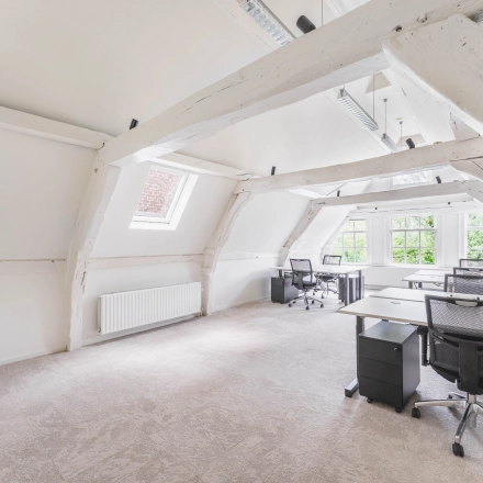 Lichte kantoorruimte op Herengracht 221 in Amsterdam Grachtengordel met houten balken, bureaus en bureaustoelen, ideaal om te huren.