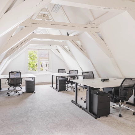 Lichte en ruime kantoorruimte aan de Herengracht 221 in Amsterdam Grachtengordel, voorzien van bureaus en stoelen. Deze open werkruimte biedt een uitnodigende omgeving voor bedrijven die een kantoorpand willen huren.