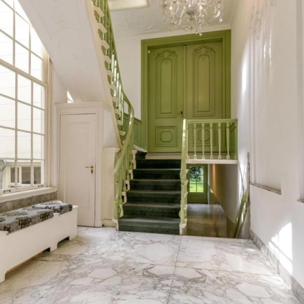 Historisch kantoorpand aan de Herengracht 338 in de Amsterdam Grachtengordel met marmeren vloeren en een decoratieve groene trap, beschikbaar voor huur.
