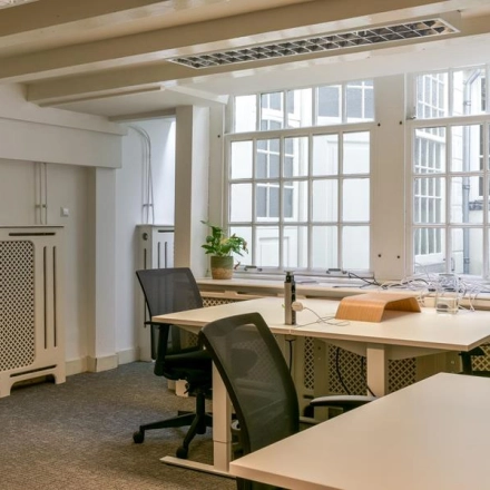 Kantoor aan de Herengracht 338 in Amsterdam Grachtengordel met moderne bureaus en stoelen in een lichte ruimte, geschikt voor kantoorruimte huren. Grote ramen zorgen voor veel natuurlijk licht.
