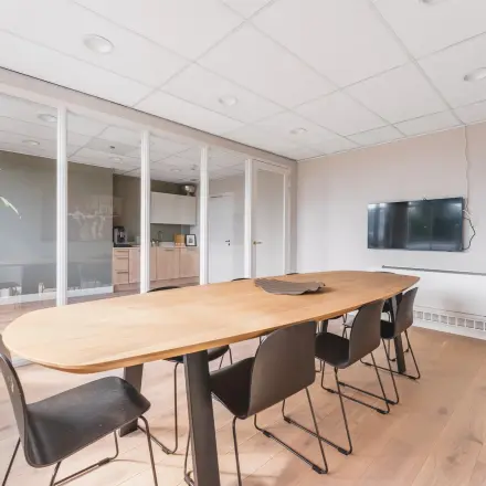 Moderne kantoorruimte huren aan de Herengracht in Amsterdam Grachtengordel met een vergadertafel, stoelen en glazen scheidingswanden.