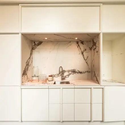 Stijlvolle keukenhoek in het kantoorpand aan de Keizersgracht 264 in Amsterdam Grachtengordel, met marmeren achterwand en moderne wite kasten. Ideaal voor kantoorruimte huren.