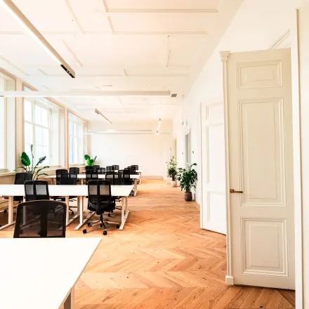 Lichte kantoorruimte te huur aan de Keizersgracht 264 in Amsterdam Grachtengordel, met houten vloer, bureaus en stoelen. Ideaal voor zakelijke bijeenkomsten of co-working. Grote ramen zorgen voor veel natuurlijk licht.