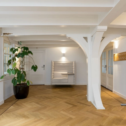 Kantoorruimte te huur op Keizersgracht 452, Amsterdam Grachtengordel, met een houten vloer, een plant in de hoek en een zithoek bij de muur.