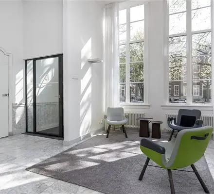 Lichte kantoorruimte te huur aan de Keizersgracht 62-64 in Amsterdam Grachtengordel met hoge ramen, moderne meubels en stijlvolle vloer, ideaal voor vergaderingen of als ontvangstruimte.