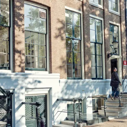 Exterieur van het kantoorpand aan Keizersgracht 62-64 in Amsterdam Grachtengordel met fietsen langs de gevel.