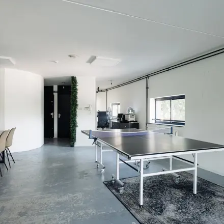 Kantoorruimte aan Weesperstraat 394-396 in Amsterdam Grachtengordel met pingpongtafel en vergaderstoelen. Ideaal voor wie kantoorruimte wil huren in een inspirerende omgeving.