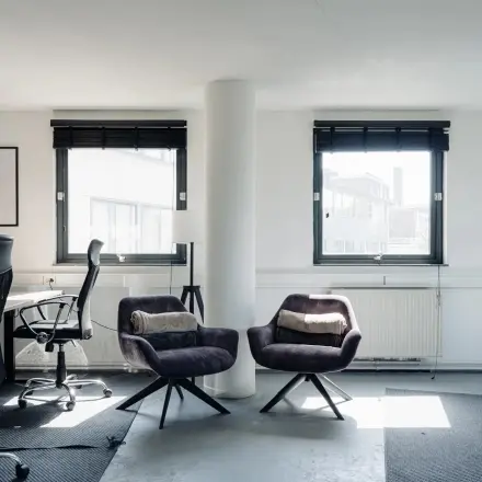 Gemeubileerde kantoorruimte te huur aan de Weesperstraat 394-396 in Amsterdam Grachtengordel met moderne stoelen, bureau en veel natuurlijk licht.