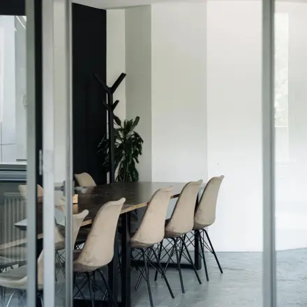 Een moderne ruimte in een kantoorpand op Weesperstraat 394-396, Amsterdam Grachtengordel. Het interieur is gemeubileerd met een grote tafel en comfortabele stoelen, geschikt voor vergaderingen.
