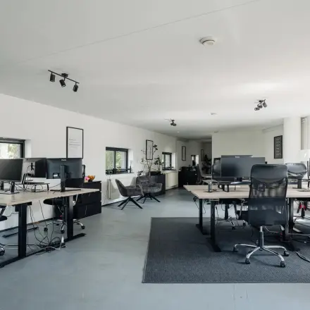 Open kantoorruimte te huur in Amsterdam Grachtengordel op Weesperstraat 394-396, modern ingericht met bureaus, stoelen en computers. Veel lichtinval en een ruimtelijke indeling ideaal voor zakelijke activiteiten.