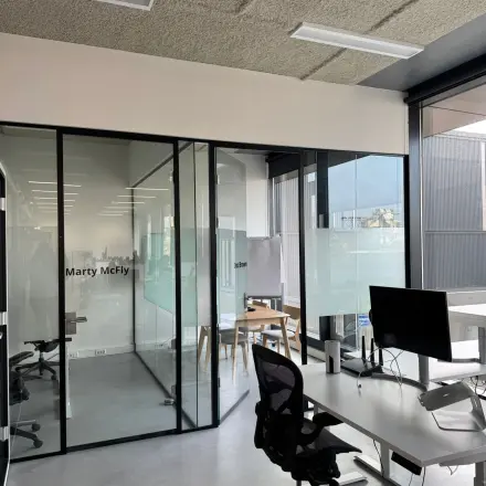 Moderne kantoorruimte op Moermanskkade 303, Amsterdam Houthavens, met glazen wanden, bureaus en stoelen, ideaal voor het huren van een lichte werkplek.