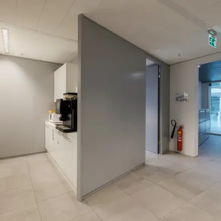 Moderne kantoorruimte met kitchenette op Pedro de Medinalaan 7 in Amsterdam IJburg, geschikt voor kantoorhuur. Strakke oppervlakken en tegelvloeren geven een professionele uitstraling.