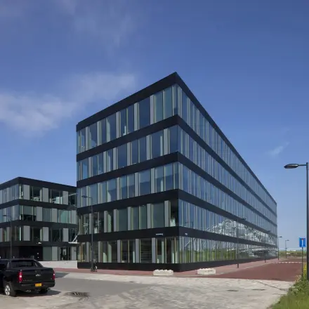Modern kantoorpand aan Pedro de Medinalaan 7, Amsterdam IJburg, met glazen gevels en strakke lijnen. Ideaal voor kantoorruimte huren.