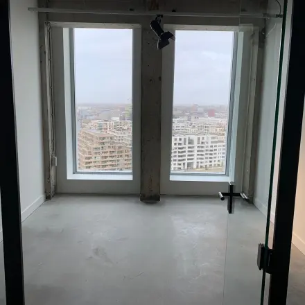 Ongebruikte kantoorruimte te huur op Overhoeksplein 1 in Amsterdam Noord met uitzicht op de stad door grote ramen.