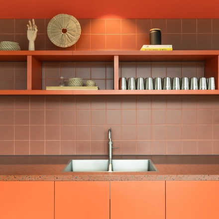 Moderne, oranje pantry in kantoorpand Papaverhof 58 in Amsterdam Noord met minimalistische inrichting en keukenapparatuur. Ideaal voor korte pauzes tijdens het kantoorwerk.