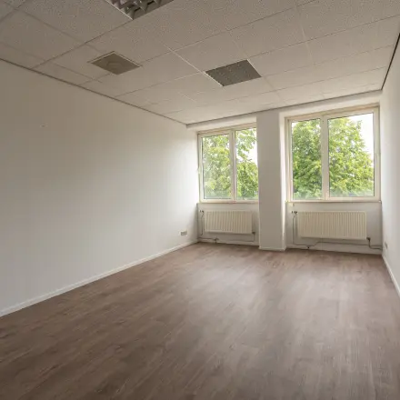 Lege kantoorruimte met ramen die uitzicht bieden op groen, ideaal voor kantoorruimte huren aan de James Wattstraat 71 in Amsterdam Oost.