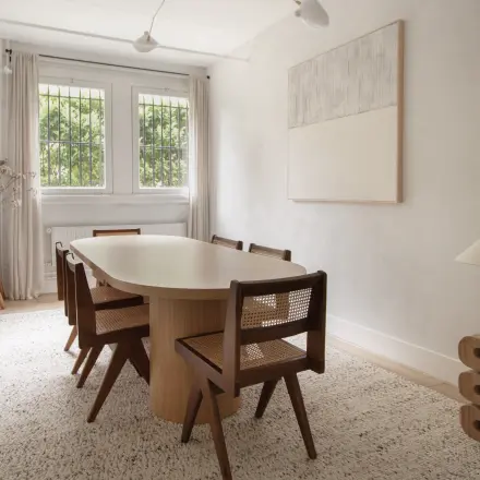 Verfijnde en lichte kantoorruimte te huur aan de Emmalaan 7-9 in Amsterdam Oud Zuid, met een stijlvolle houten tafel en stoelen, grote ramen en moderne decoraties.