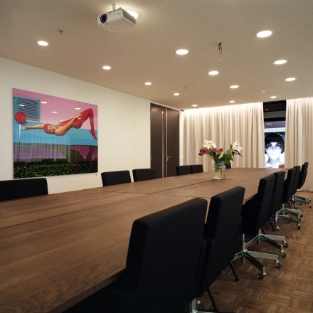 Moderne vergaderruimte in kantoorpand op Johan Huizingalaan 400, Amsterdam Riekerpolder met lange houten tafel, comfortabele stoelen en creatieve kunst aan de muur. Ideaal voor het huren van een inspirerende werkplek.