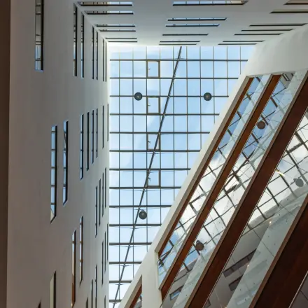 Binnenaanzicht van een modern kantoorpand op John M. Keynesplein in Amsterdam Riekerpolder, met grote glazen plafonds en verzonken verlichting. Ideaal voor kantoorruimte huren in een inspirerende omgeving.