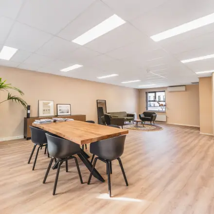 Ruime kantoorruimte te huur aan de Arlandaweg 92, Amsterdam Sloterdijk. Het interieur is voorzien van een grote tafel en stoelen en een zithoek met banken. Ideaal voor flexibele werkplekken.