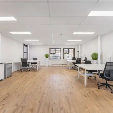 Open, lichte kantoorruimte op Arlandaweg 92 in Amsterdam Sloterdijk met houten vloer, meerdere bureaus en stoelen. Geschikt voor kantoorruimte huren.