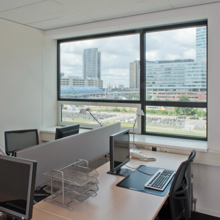 Zicht op een kantoorpand in Amsterdam Sloterdijk met bureau-opstelling en uitzicht op moderne gebouwen, ideaal voor kantoorruimte huren.
