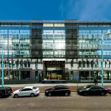 Zakelijk kantoorpand aan de Teleportboulevard 120 in Amsterdam Sloterdijk, met moderne gevel en grote glazen ramen. Ideale locatie voor kantoorruimte huren, met parkeergelegenheid aan de voorzijde.