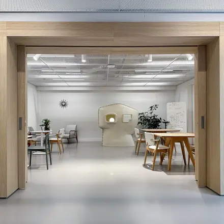 Moderne kantoorruimte op Haarlemmerweg 331 in Amsterdam West, ideaal voor het huren van een creatieve werkplek. Ruimte met houten accenten, tafels, stoelen en diverse werkstations.
