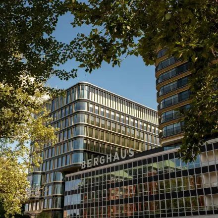 Kantoorpand Berghaus aan het Kon. Wilhelminaplein 4, Amsterdam West, te midden van groene bomen.