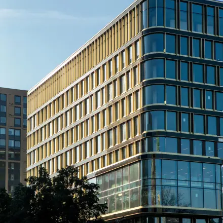 Modern kantoorpand op de hoek van Kon. Wilhelminaplein 4, Amsterdam West, met grote glazen gevels en meerdere verdiepingen, ideaal voor kantoorruimte huren.