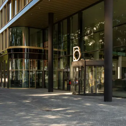 Buitenzijde van modern kantoorpand op Kon. Wilhelminaplein 4, Amsterdam West met glazen gevel en entree. Ideale locatie voor kantoorruimte huren in levendige omgeving.